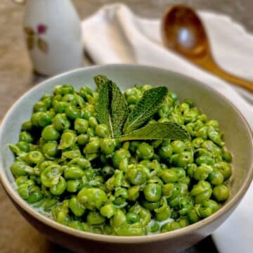 A small dish of minted smashed peas garnished with a mint leaf.