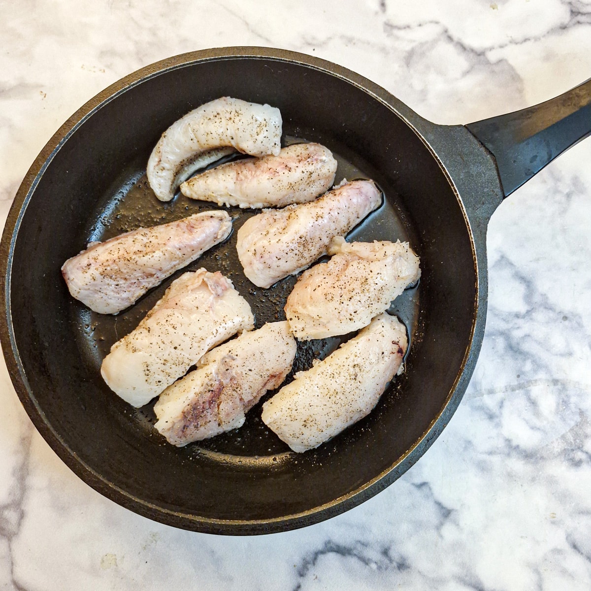 Fillets of monkfish in a frying pan.