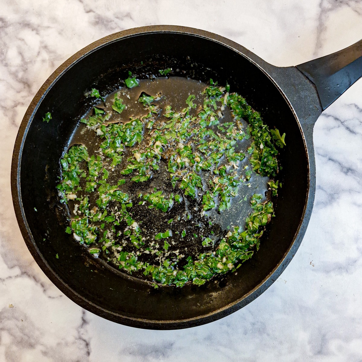 Chopped parsley and butter in a frying pan.