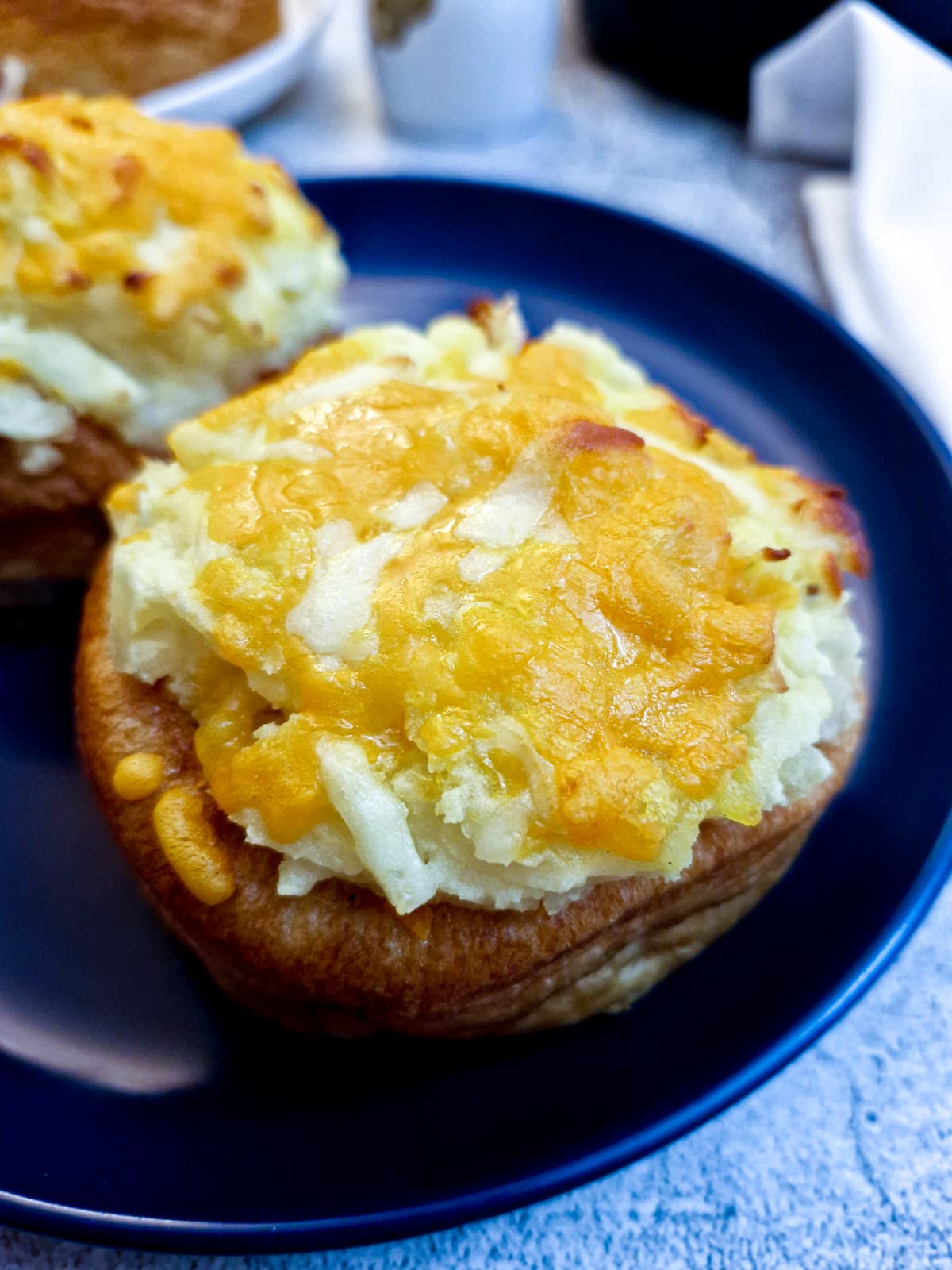 Close up of a stuffed Yorkshire pudding pie on a blue plate.