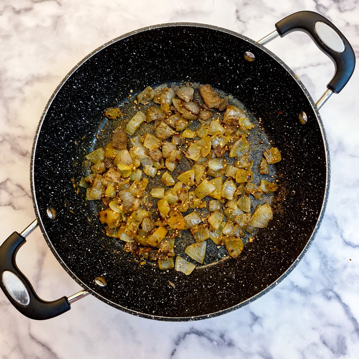 Spices and chopped onions in a pan.