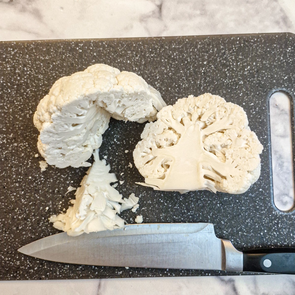 A head of cauliflower cut in half down the middle with the core removed from one half.