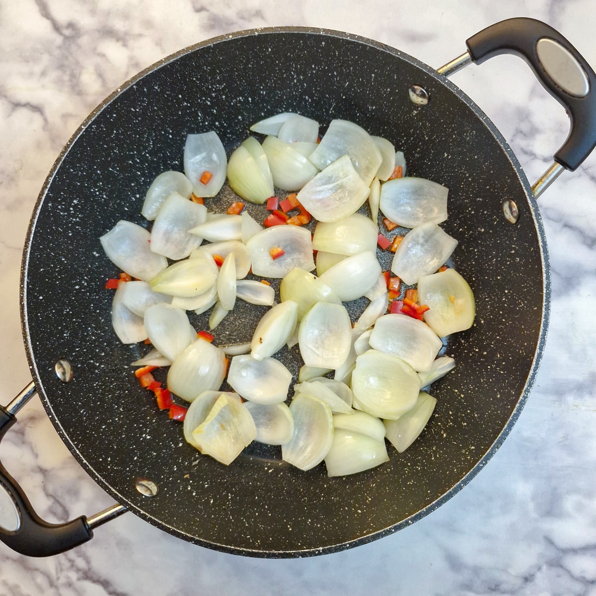 Onions and chopped chilli in a large frying pan.