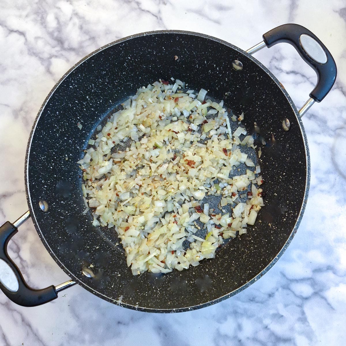 Finely chopped onions in a frying pan.