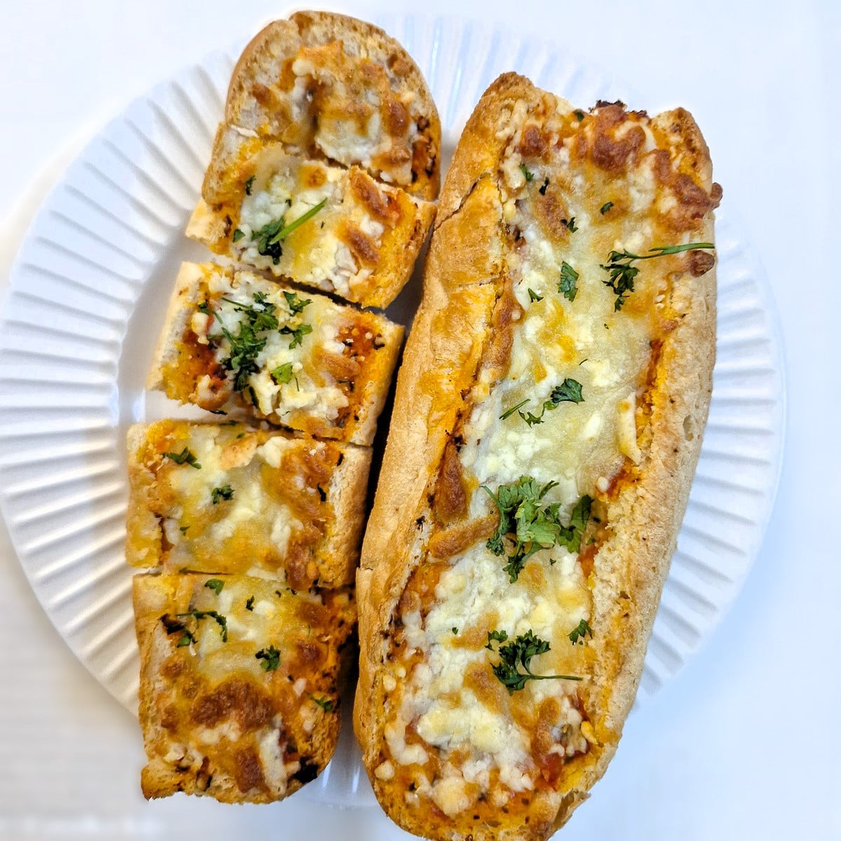 Overhead shot of 2 garlic baguettes covered with melted cheese.