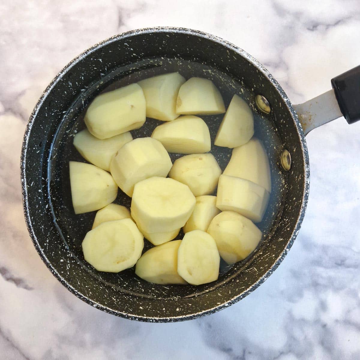 Potatoes in a saucepan of water.