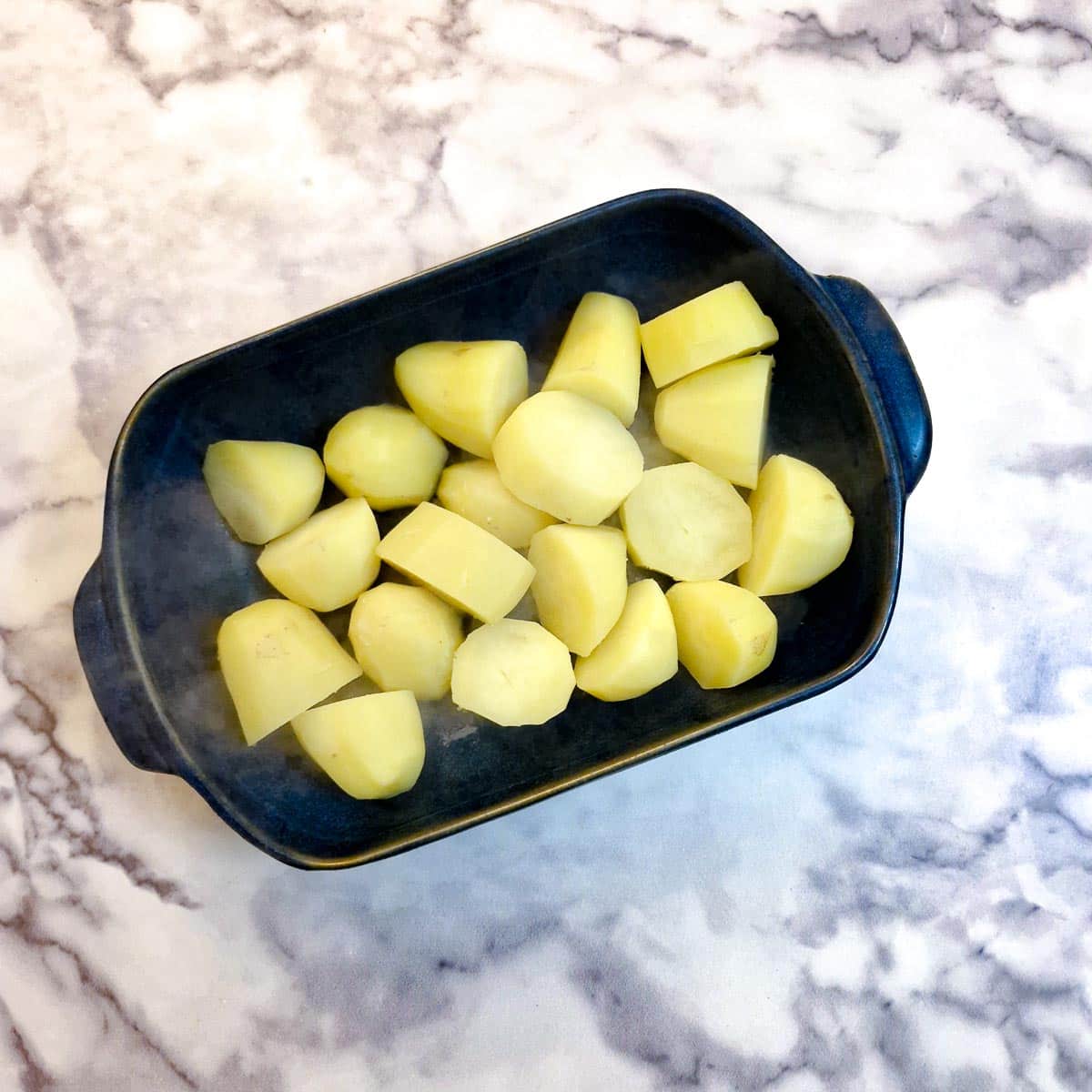 Potatoes in a blue casserole dish.