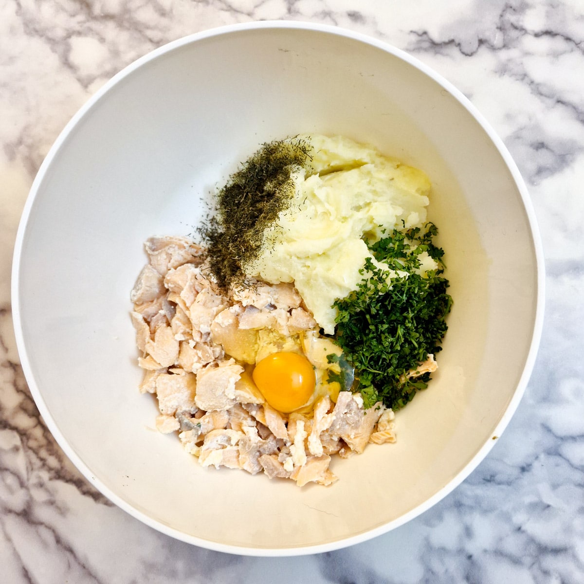 Ingredients for salmon fishcakes in a mixing bowl.