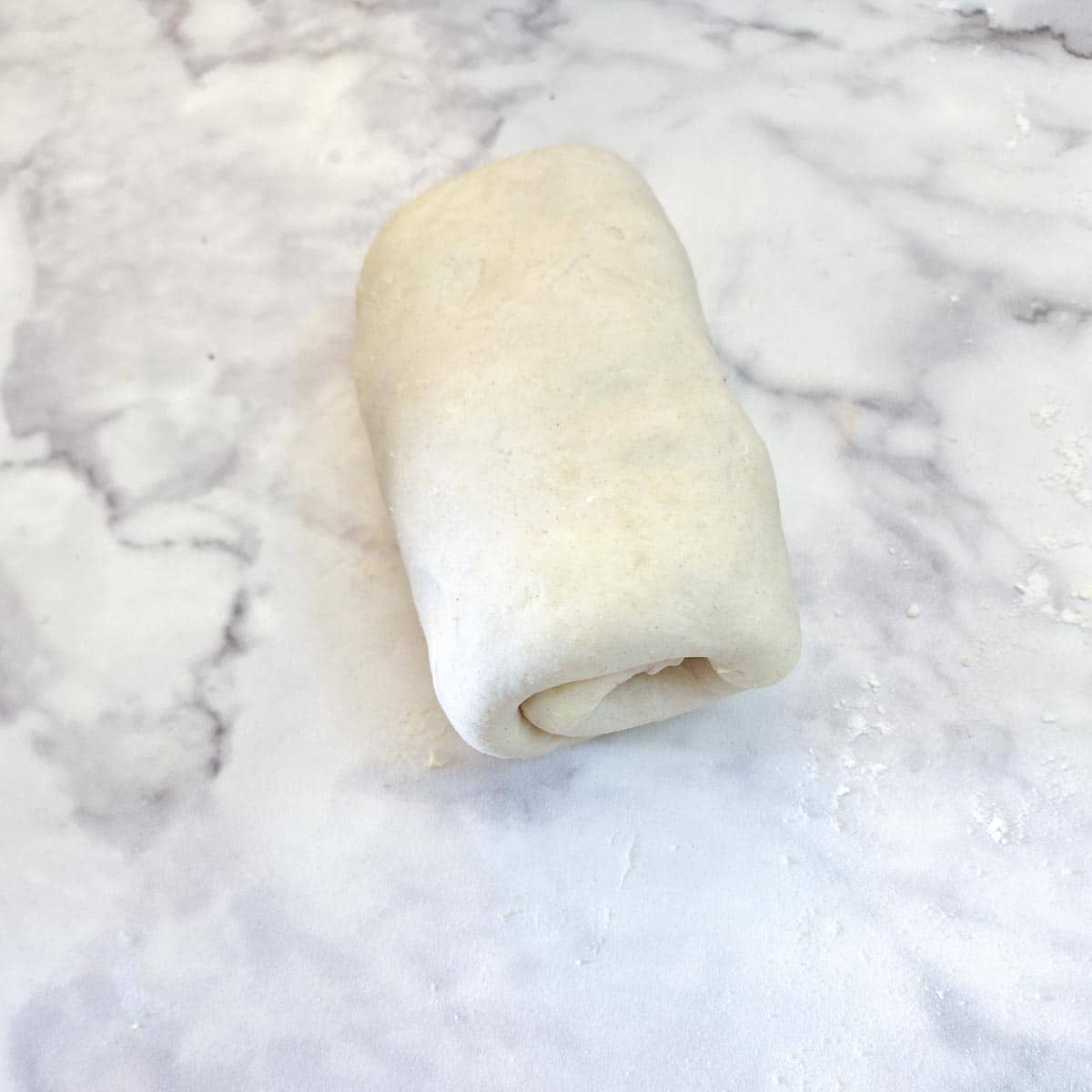 A roll of completed flaky pastry dough.