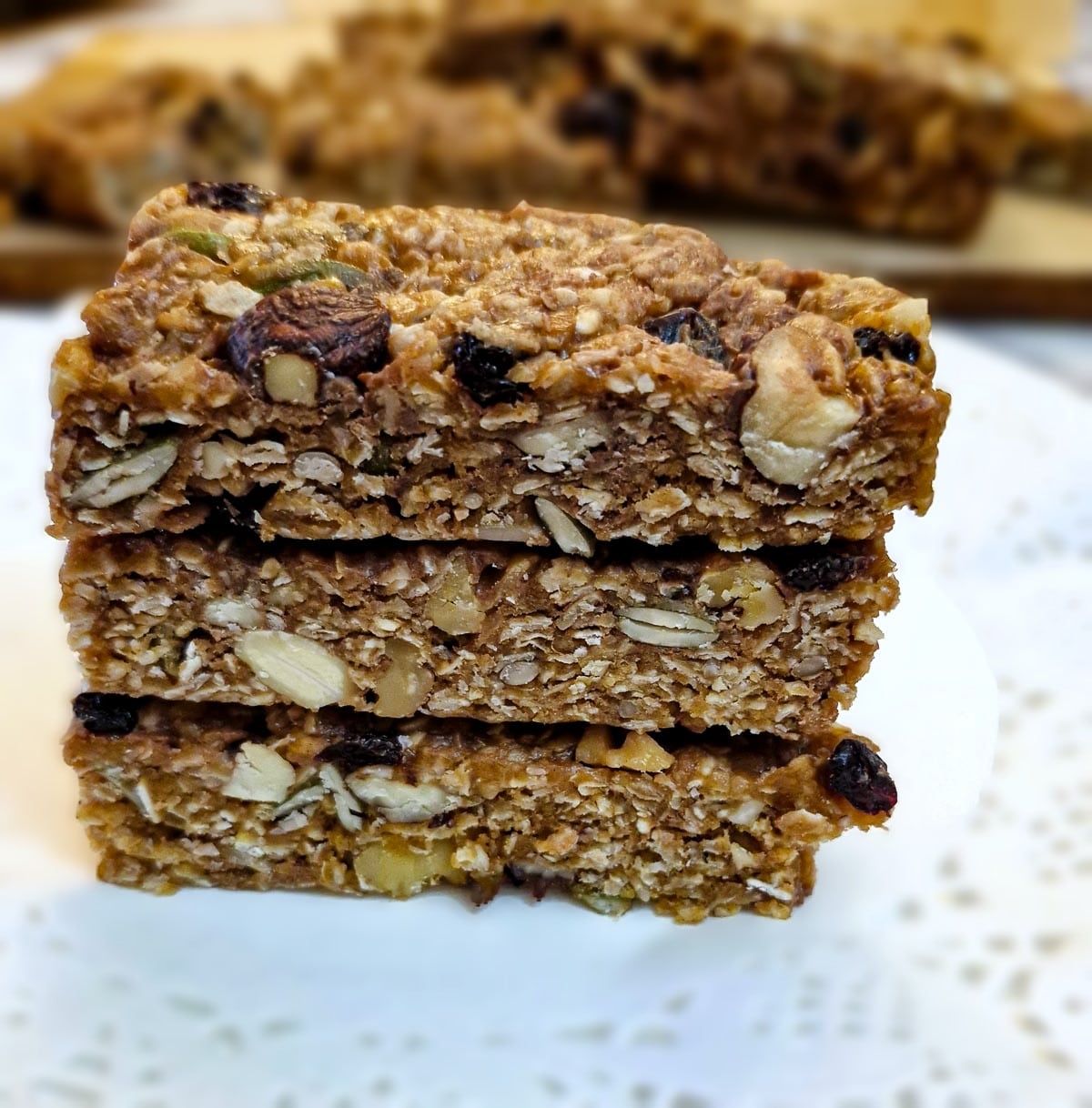 Three fruit and nut muesli bars piled on top of each other.