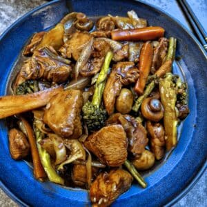 A blue dish of szechucan chicken and vegetables.