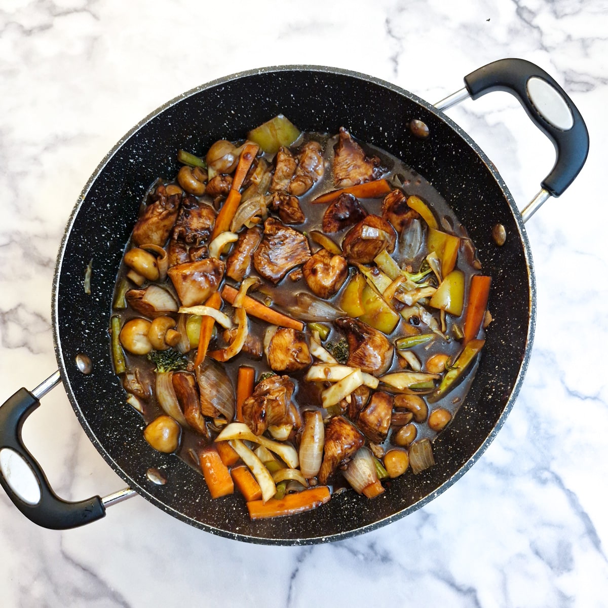 A frying pan containing the finished Szechuan chicken.