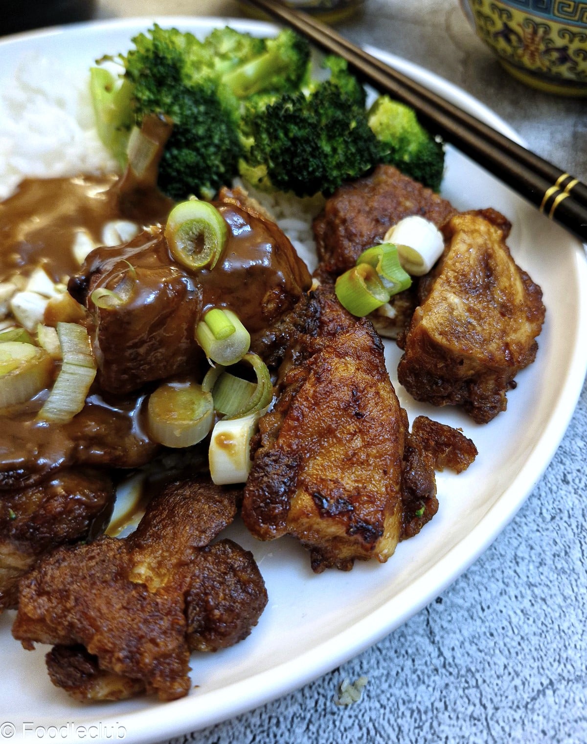 Close up of satay chicken on a white plate.