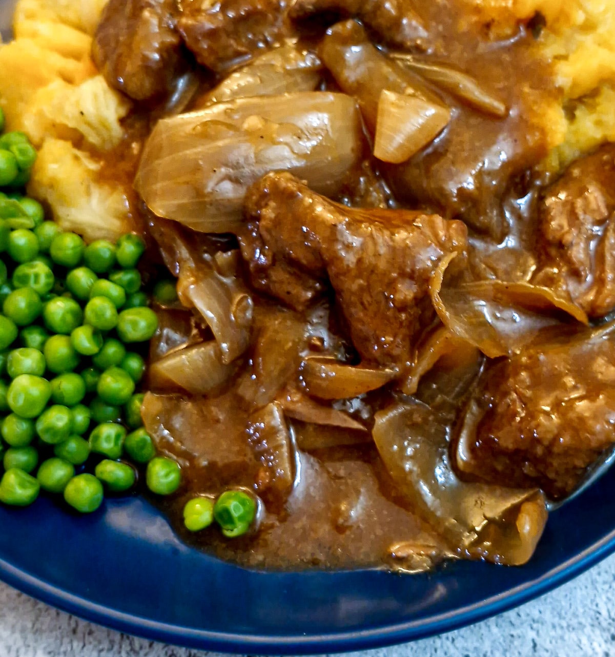 Close up of steak and onions on a blue plate.