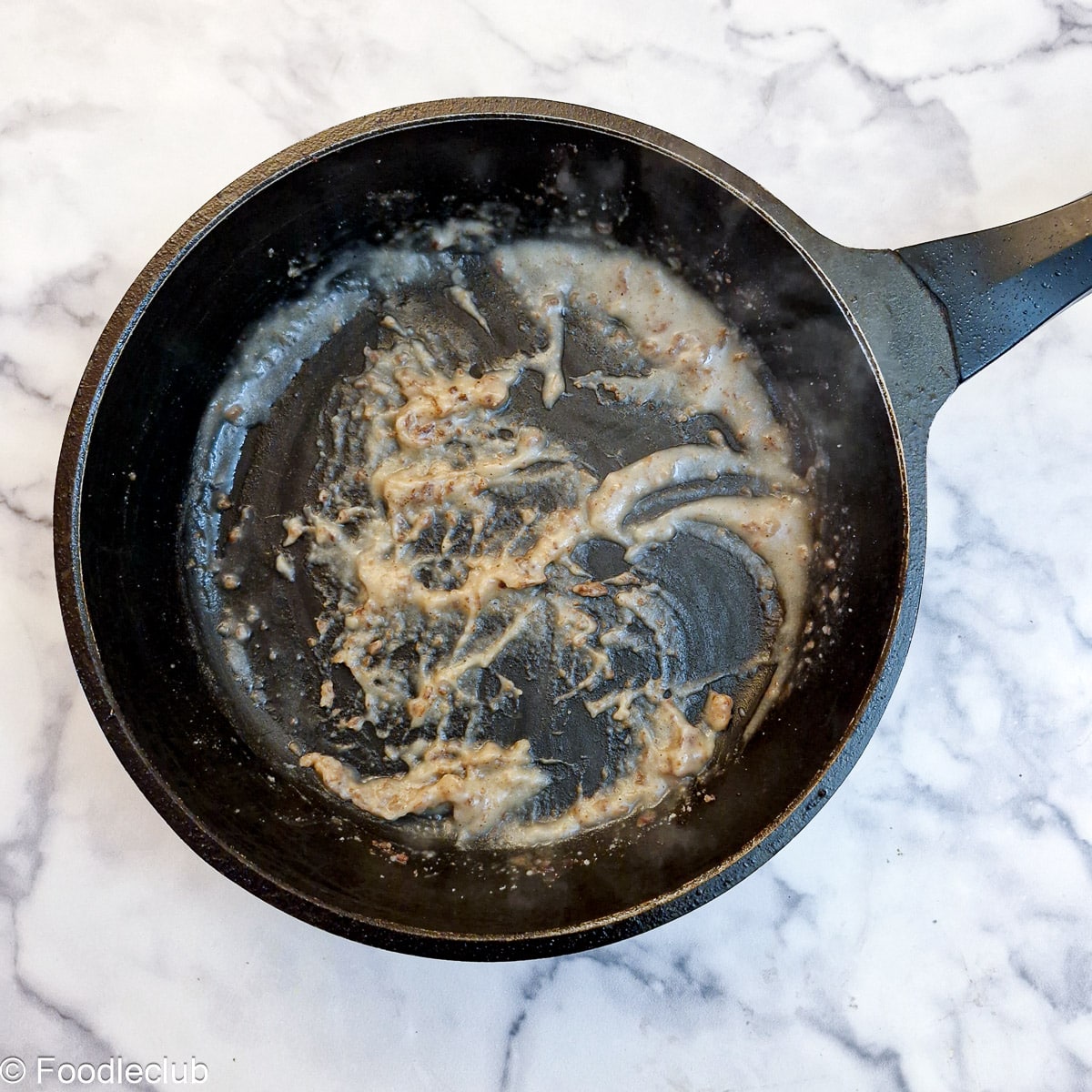 Flour combined with steak cooking juices in a frying pan.