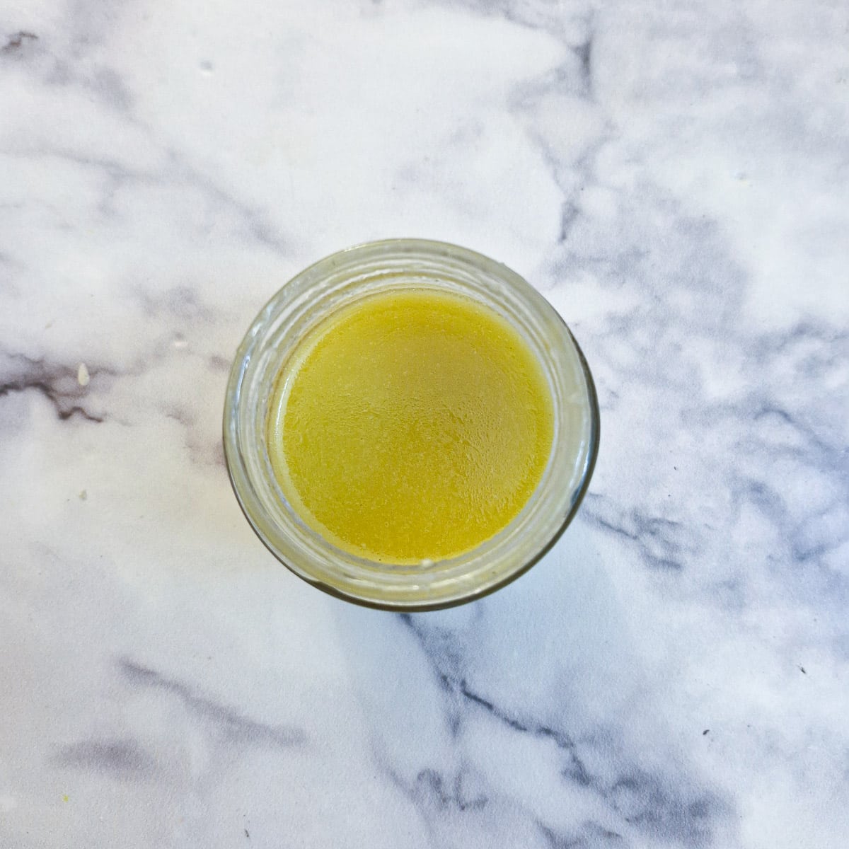 Honey and mustard salad dressing in a glass jar.