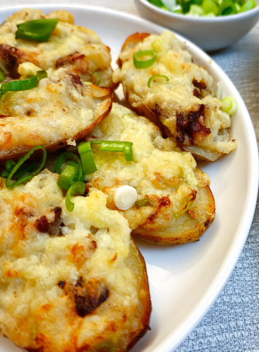 Close up of stuffed potato skins on a white plate.