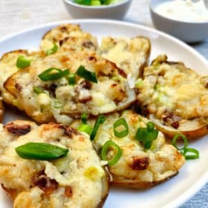 A pile of stuffed potato skins on a white plate.