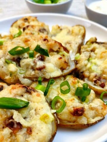 A pile of stuffed potato skins on a white plate.