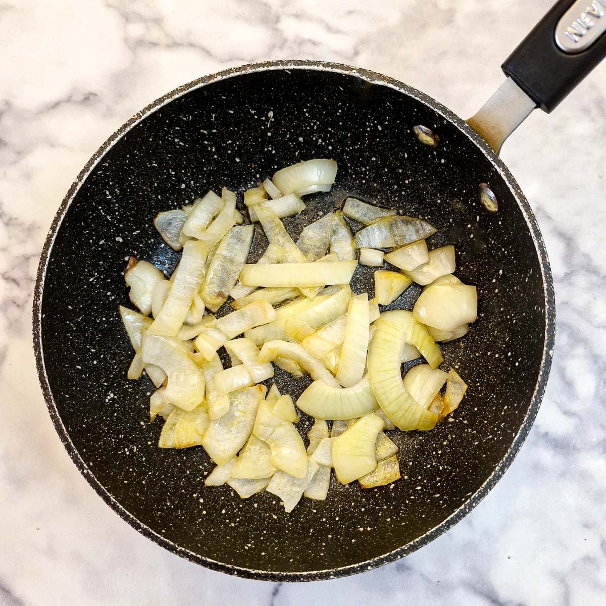 Sliced onions in a frying pan.