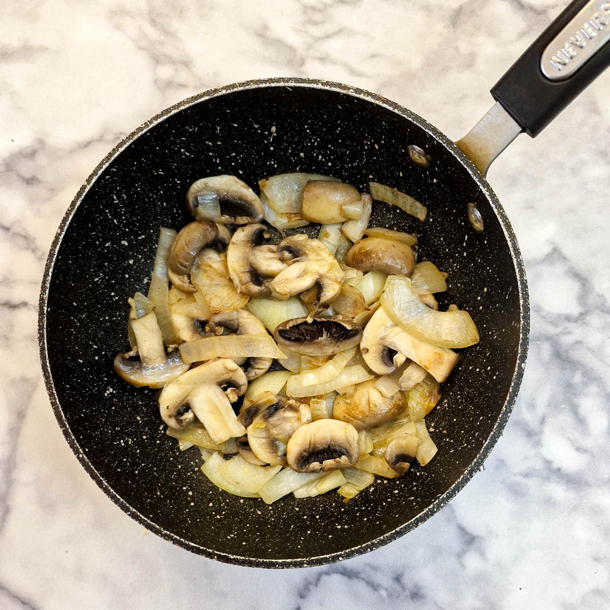 Adding mushrooms to the onions.