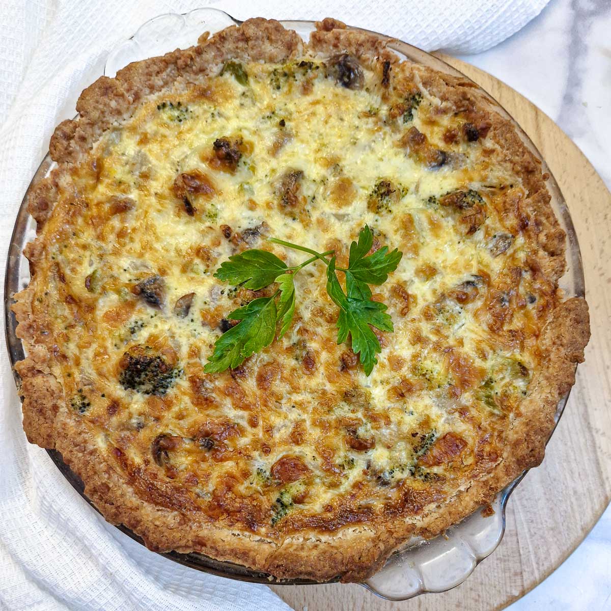 Overhead shot of a baked cheese and broccoli quiche.