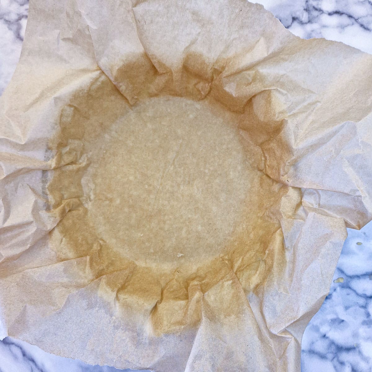 Cheese pastry pressed into a baking dish covered with greaseproof paper.