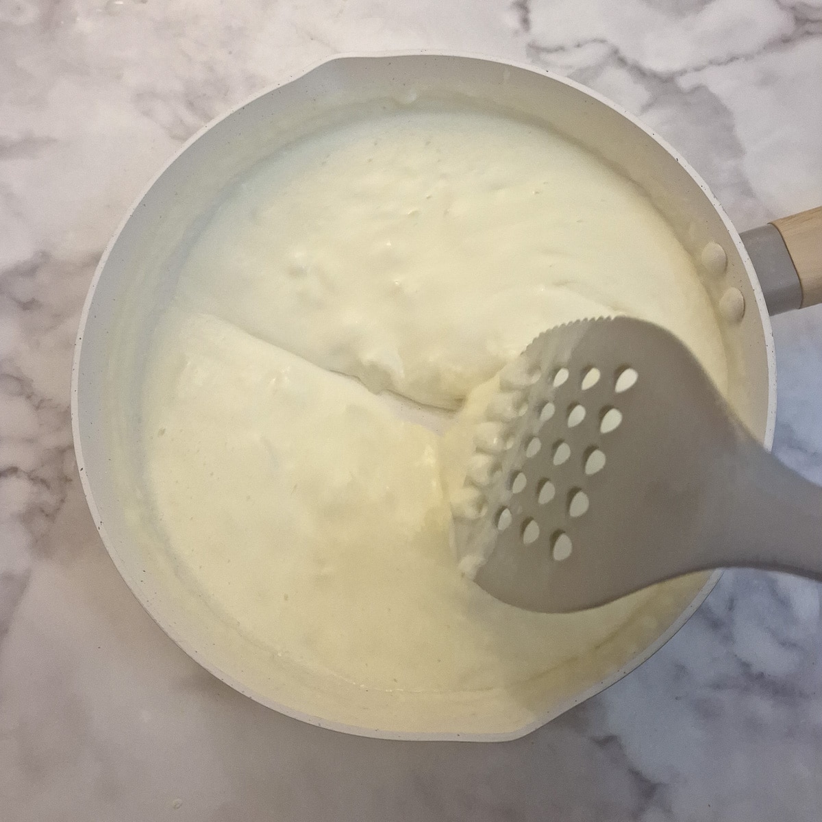 Thickened sauce leaving a trail as a spatula is drawn through it.