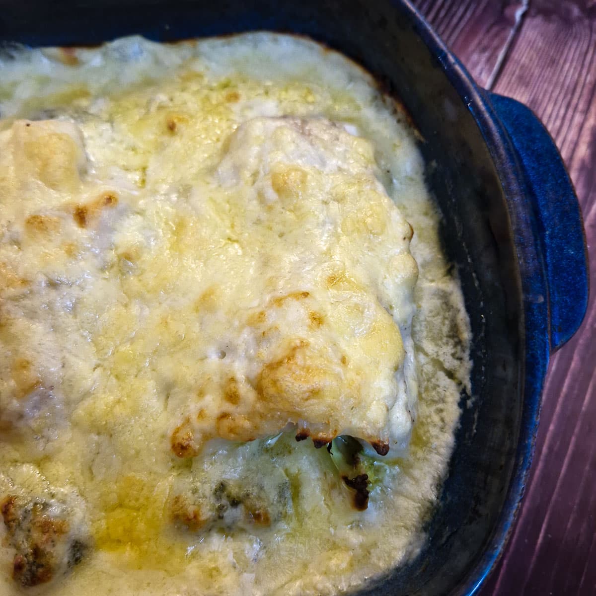 The finished dish of cod and broccoli bake covered with golden melted cheese.
