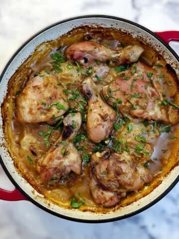 Overhead shot of a French onion chicken casserole in a red casserole dish.