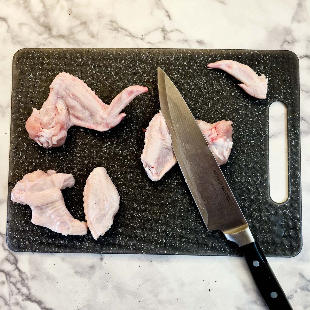 Chicken wings being separated into pieces.