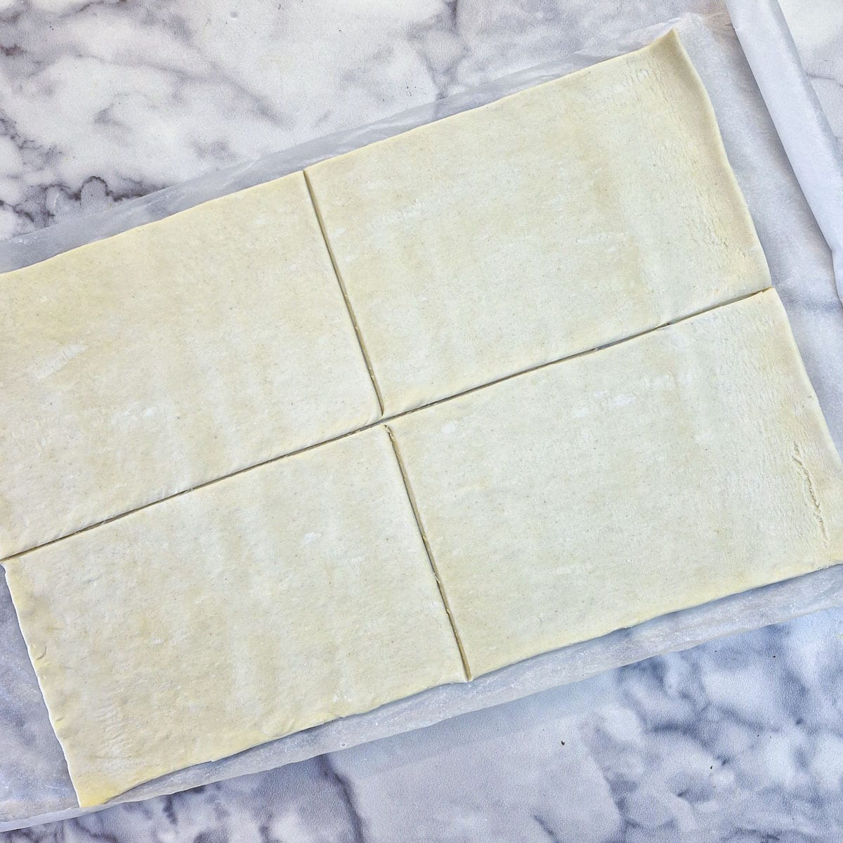 Unrolled puff pastry cut into 4 rectangles.