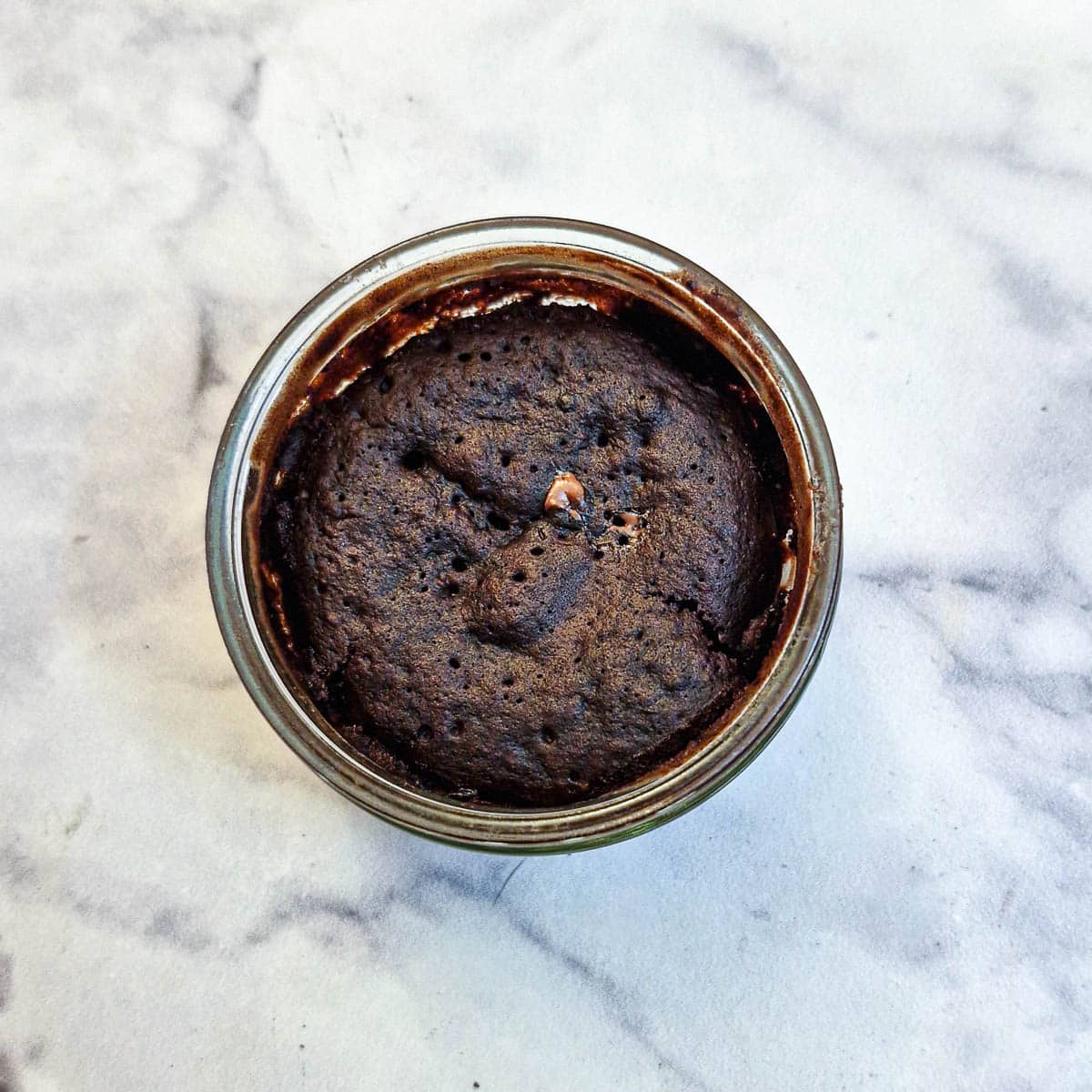 An individual chocolate pot after being cooked in the microwave.