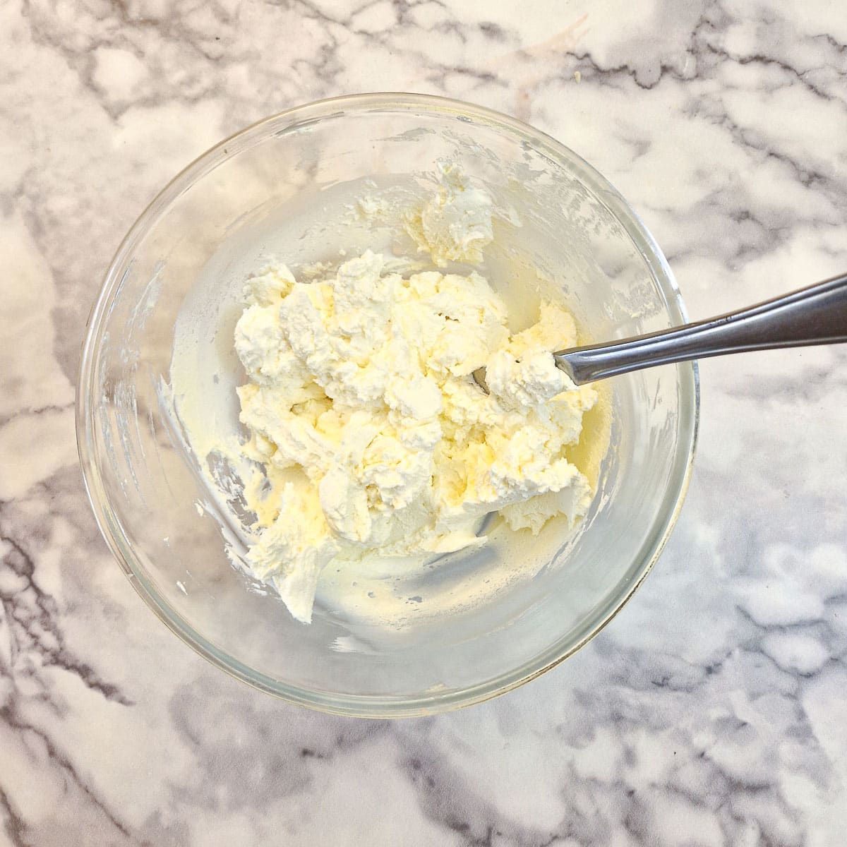 Double cream stirred into a bowl of mascarpone and icing sugar.