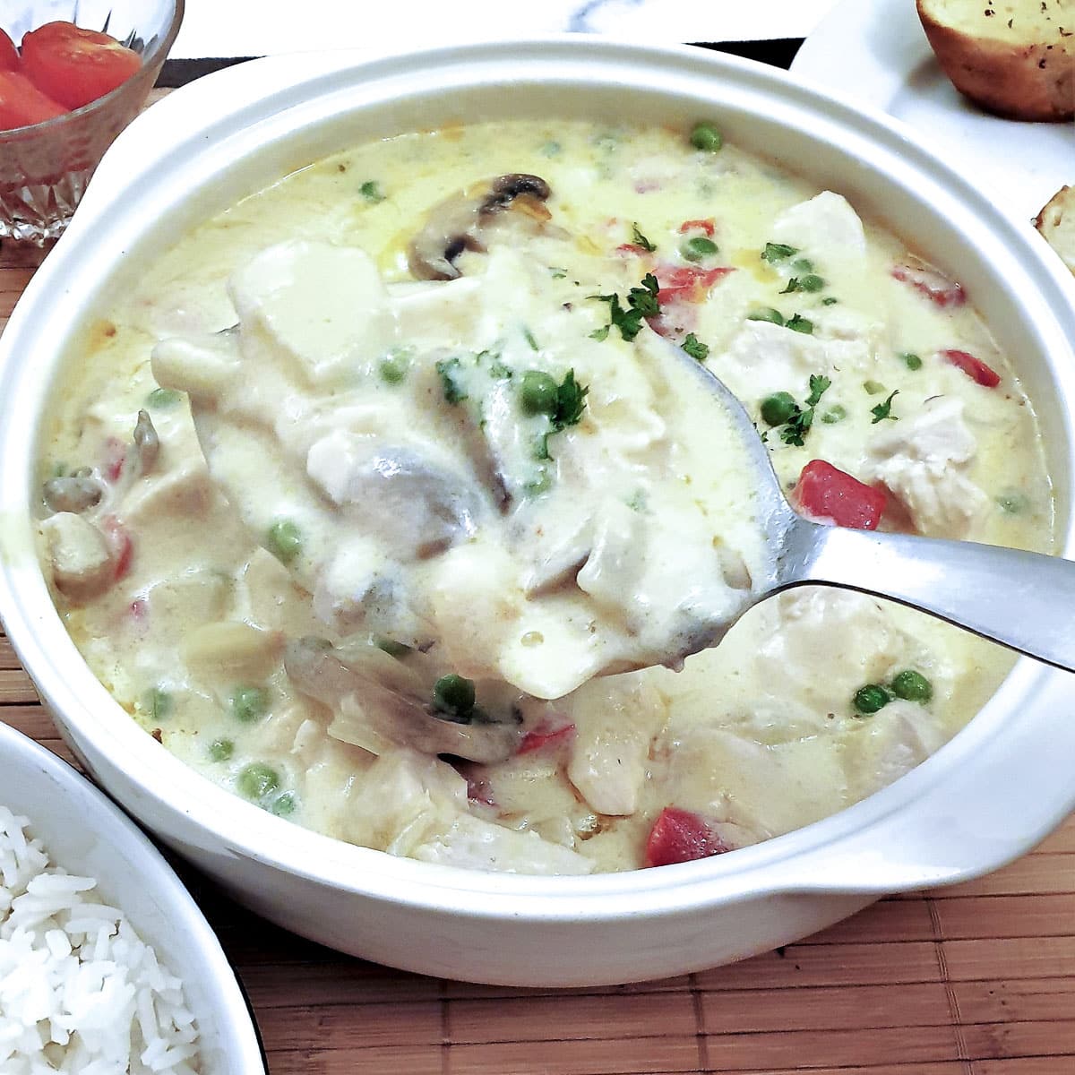 A dish of chicken a la king with a large serving spoon.