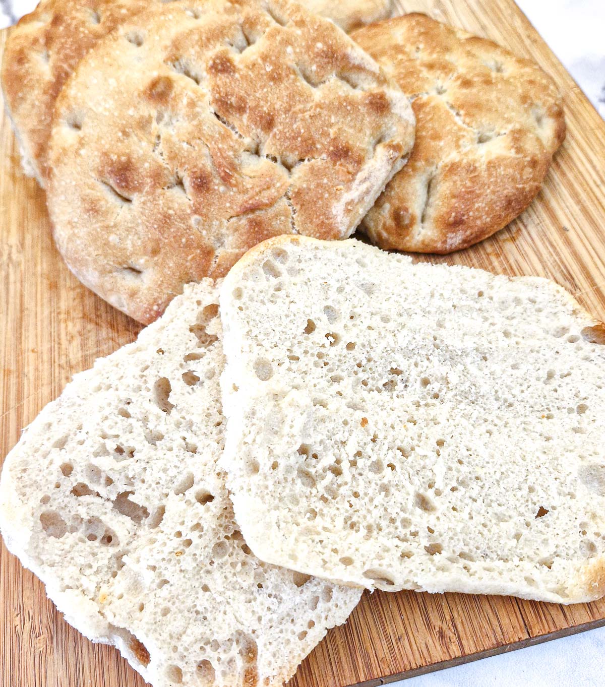 A focaccia bread roll cut in half to show the airy texture.