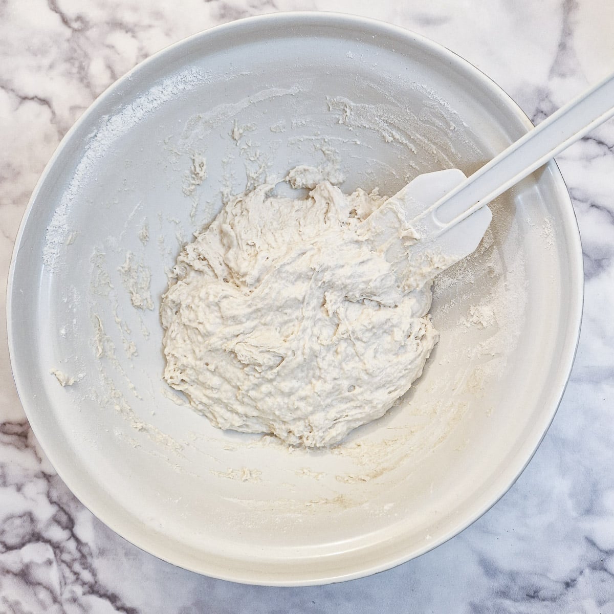 Dough being mixed with a spatula.