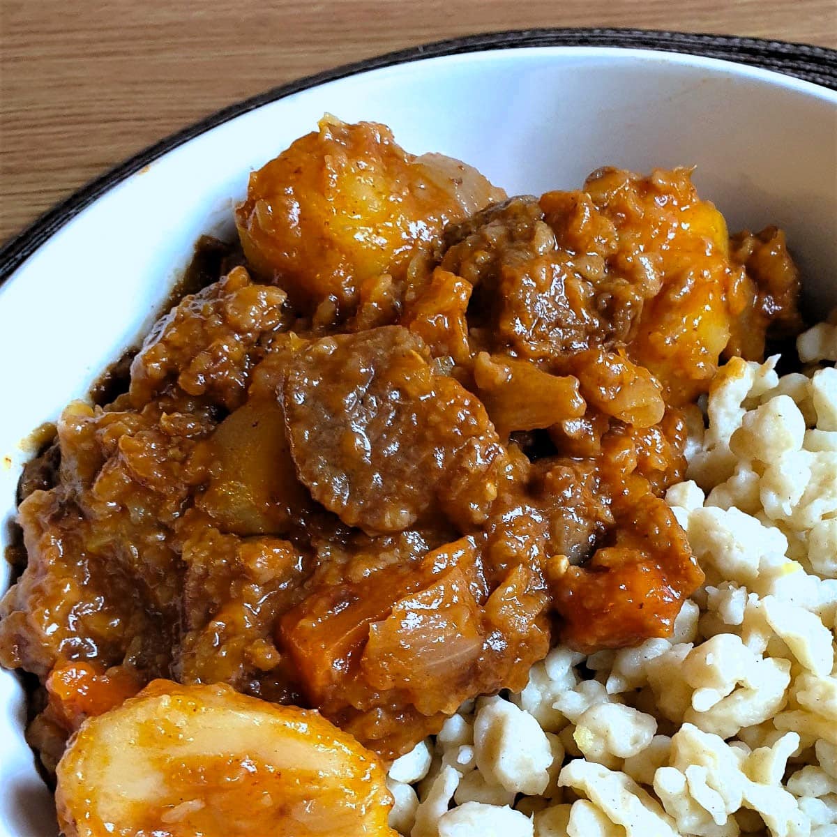 A dish of goulash with spaetzle.