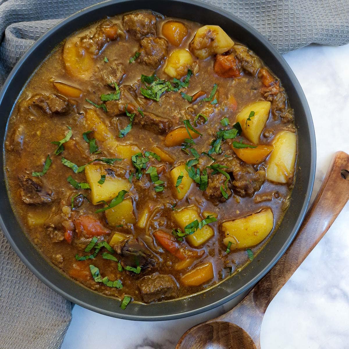 A black serving dish filled with Hungarian goulash.