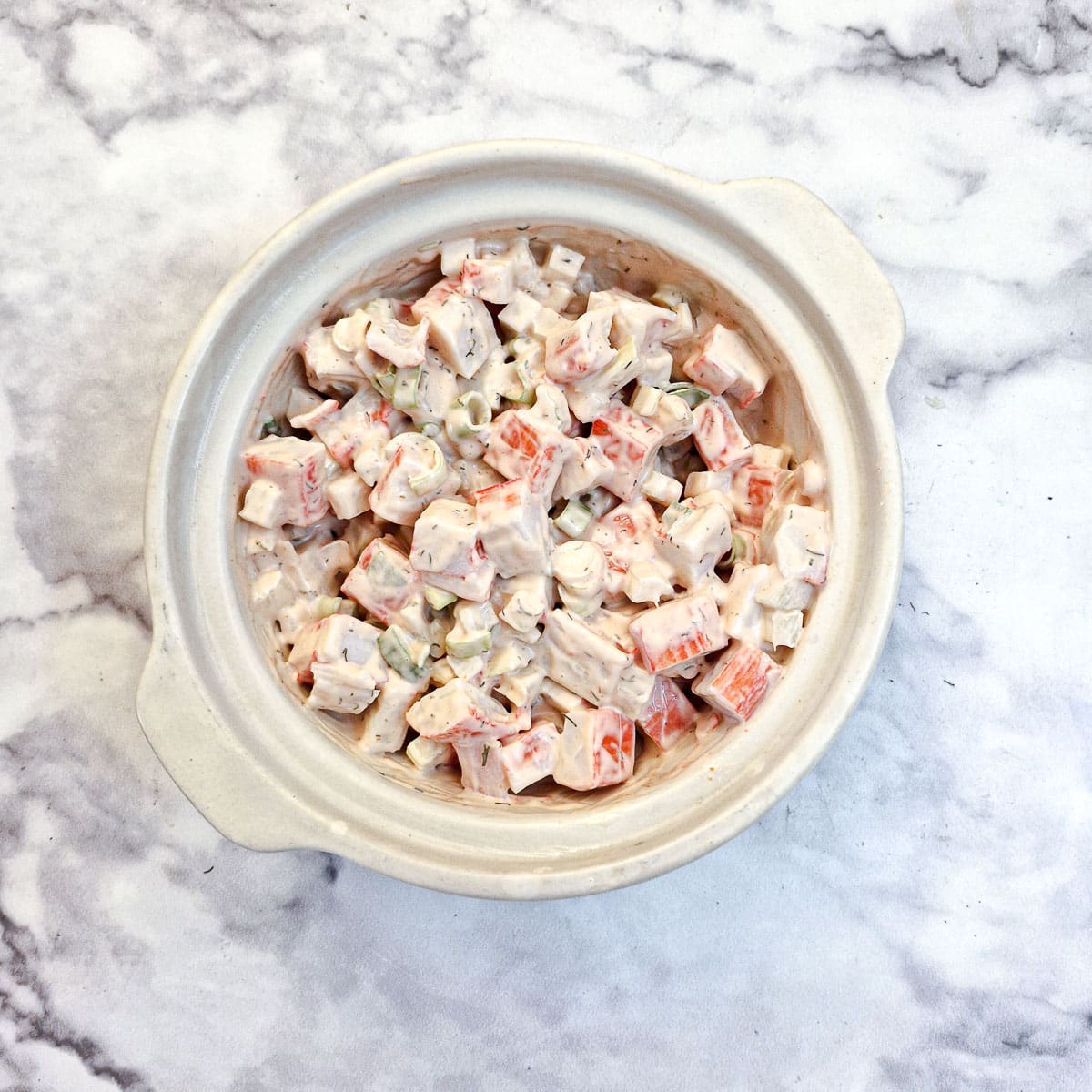 Overhead shot of imitation crab starter in a white bowl.