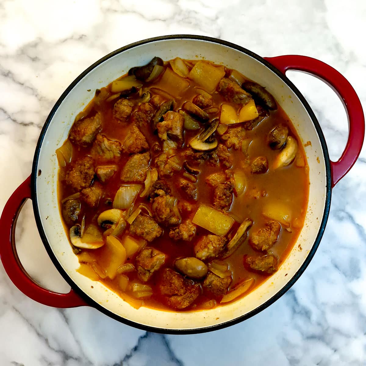 Stock and pork pieces added to vegetables.