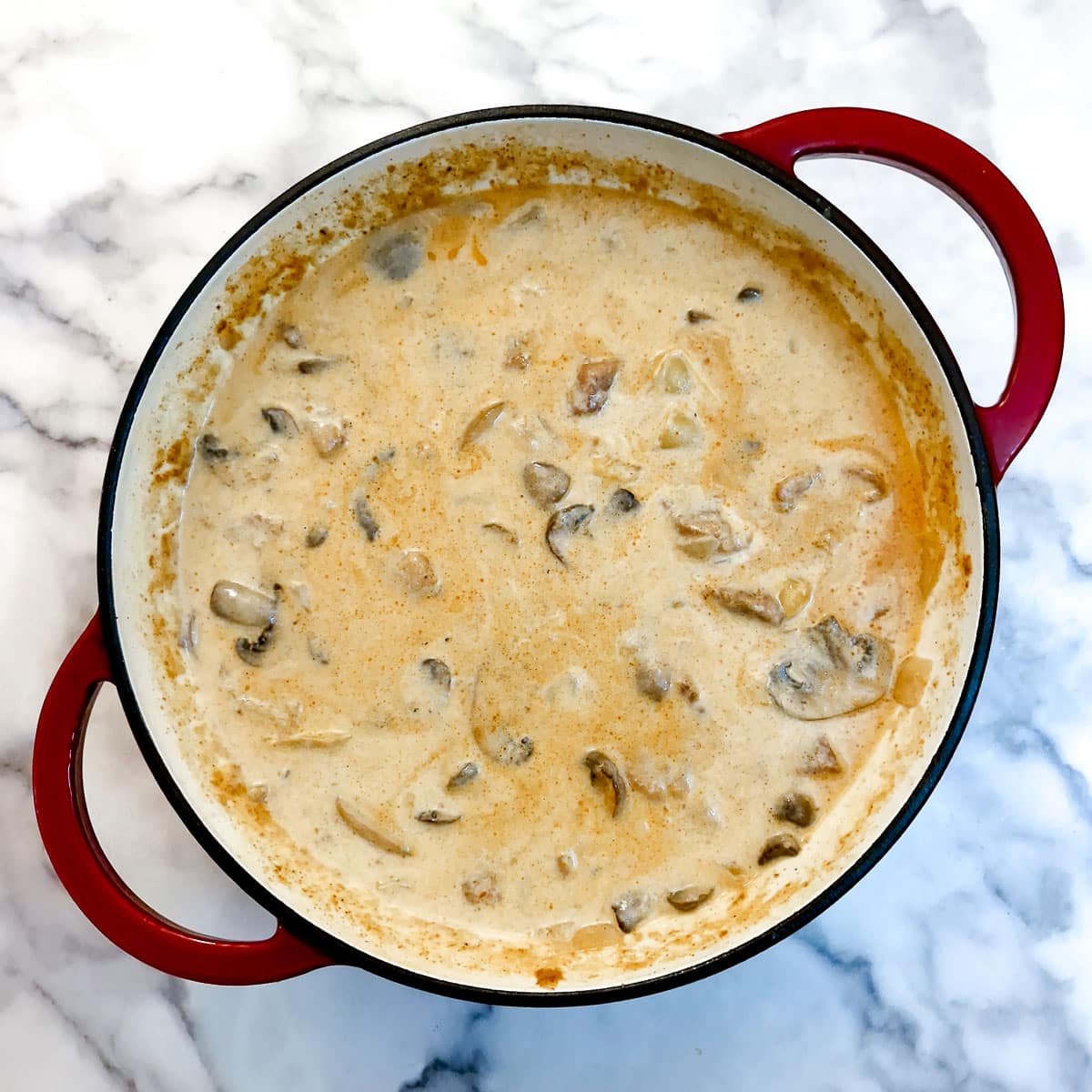 Cream stirred into pork goulash.