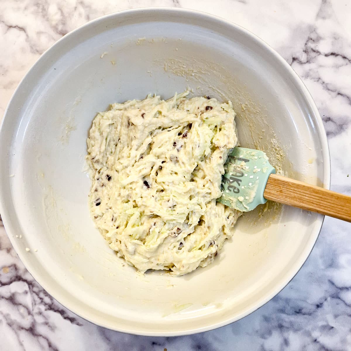 Fully combined cake batter in a white mixing bowl.