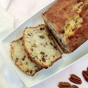 Overhead shot of an apple and pecan loaf with 2 slices lying flat on the plate.