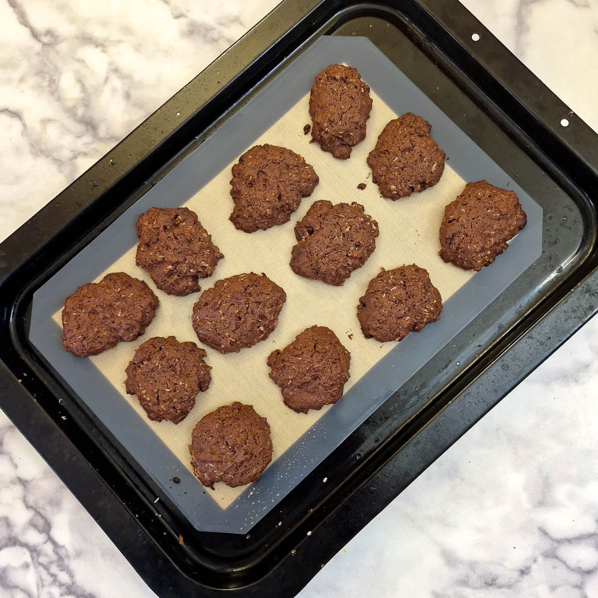 12 baked romany creams on a baking tray.