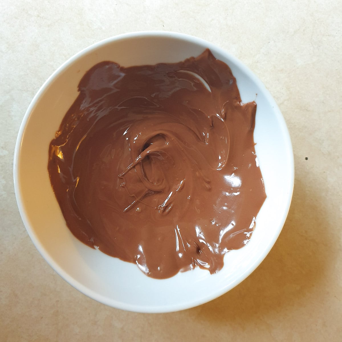 Melted chocolate in a small white bowl.