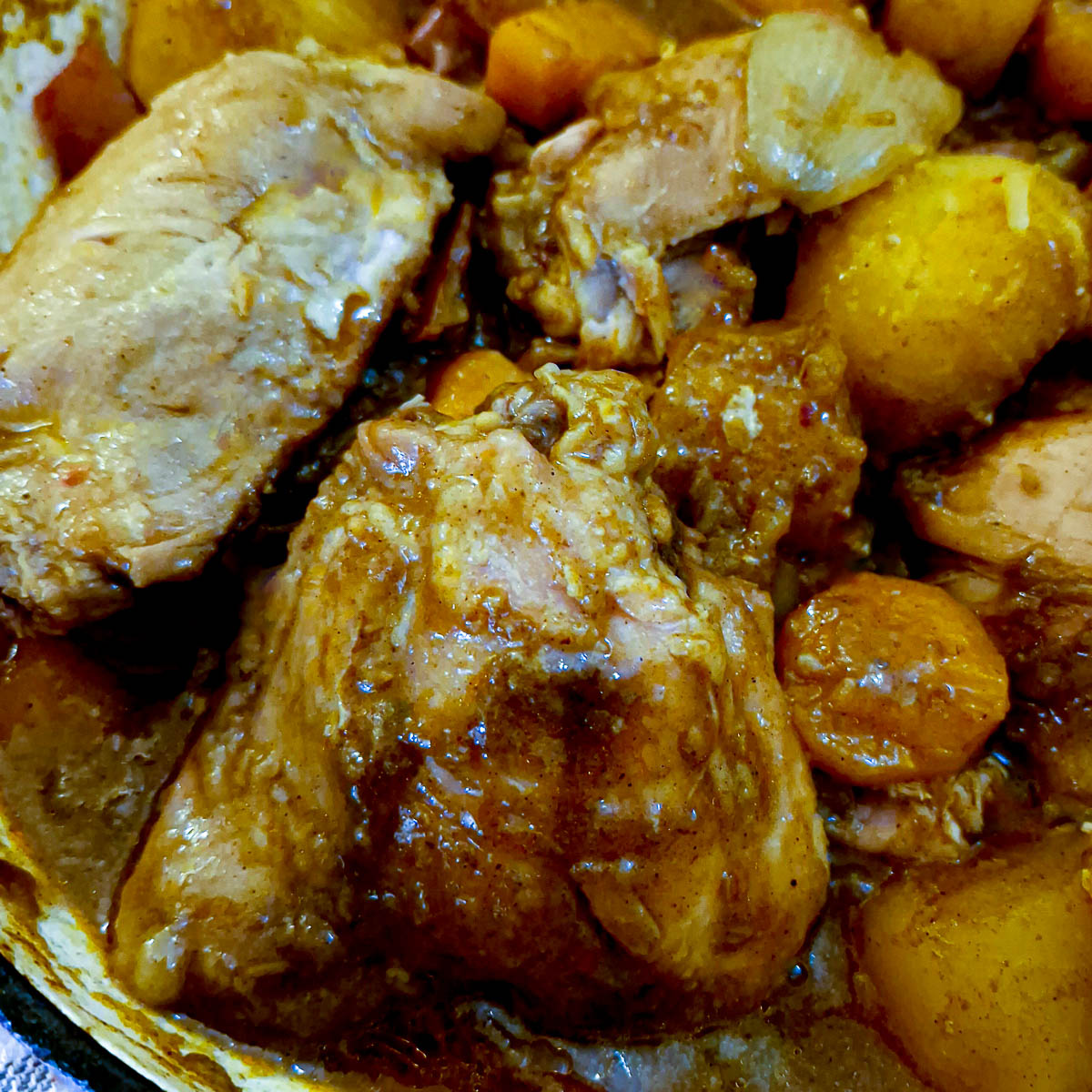 Close up of a piece of chicken coated in a thick sticky gravy.
