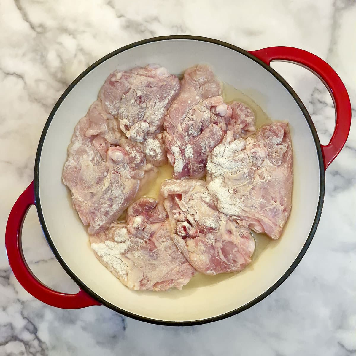 6 chicken thighs in a frying pan.