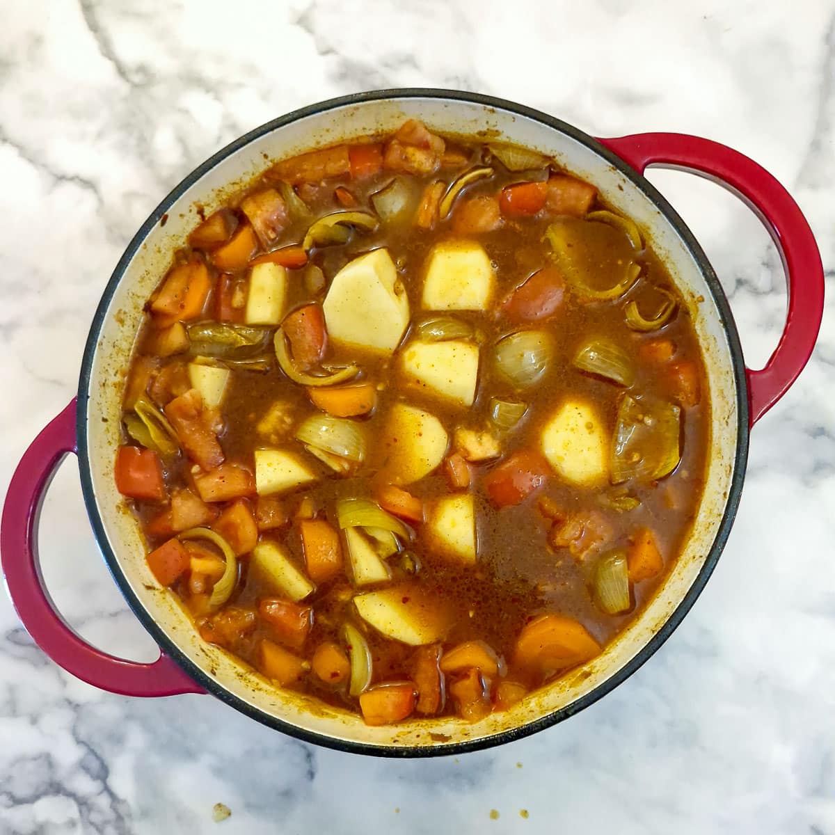 Stock and potatoes added to the base curry mixture.