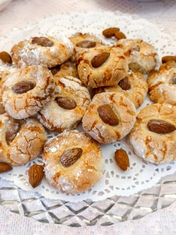 A glass plate with a pile of lemon amaretti biscuits.